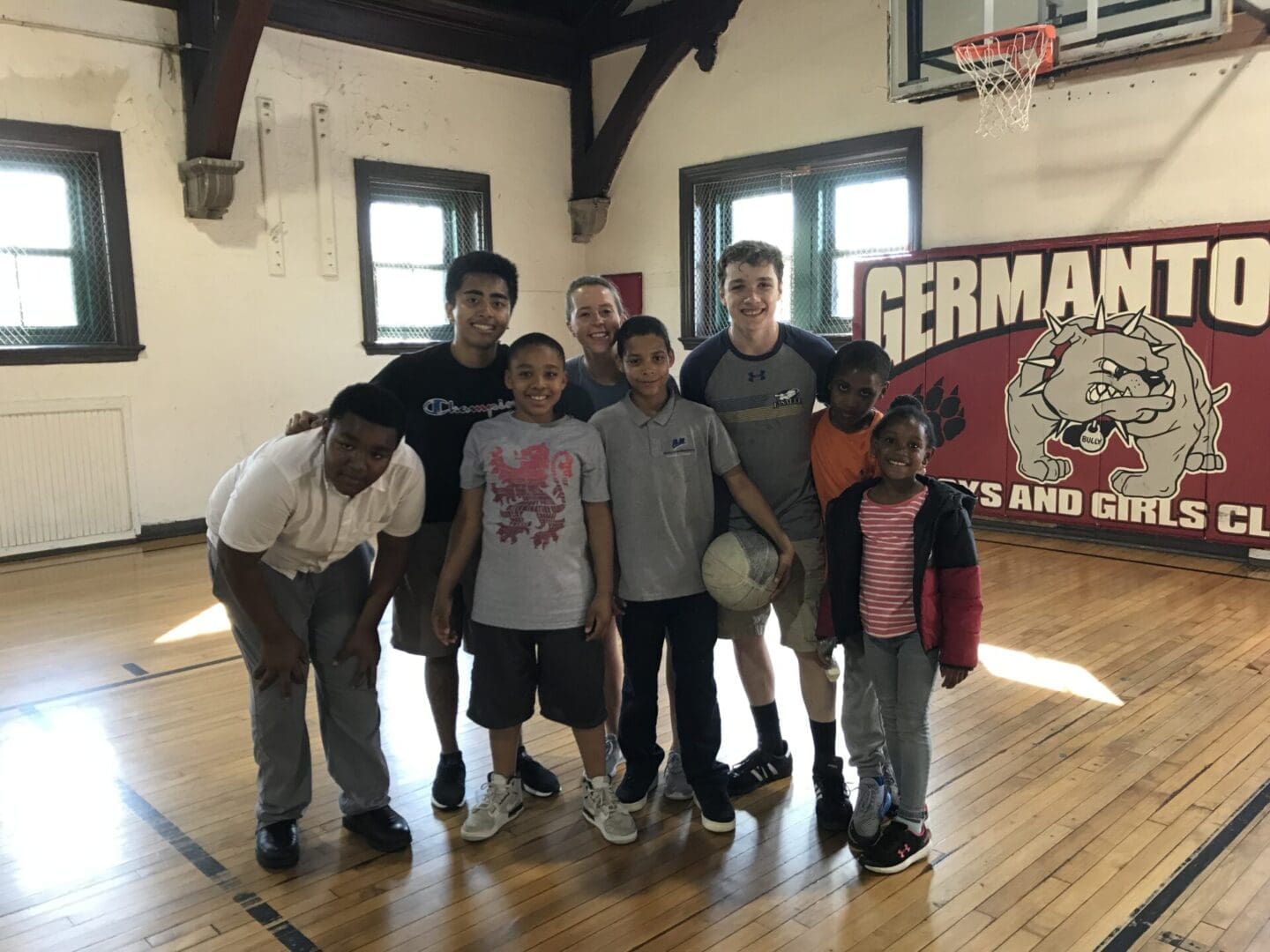Group in gym posing with basketball.