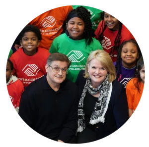 Group of adults and children smiling together.